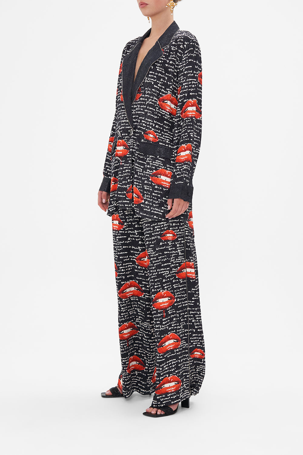 Side view of model wearing CAMILLA black blazer in Chaos Magic print