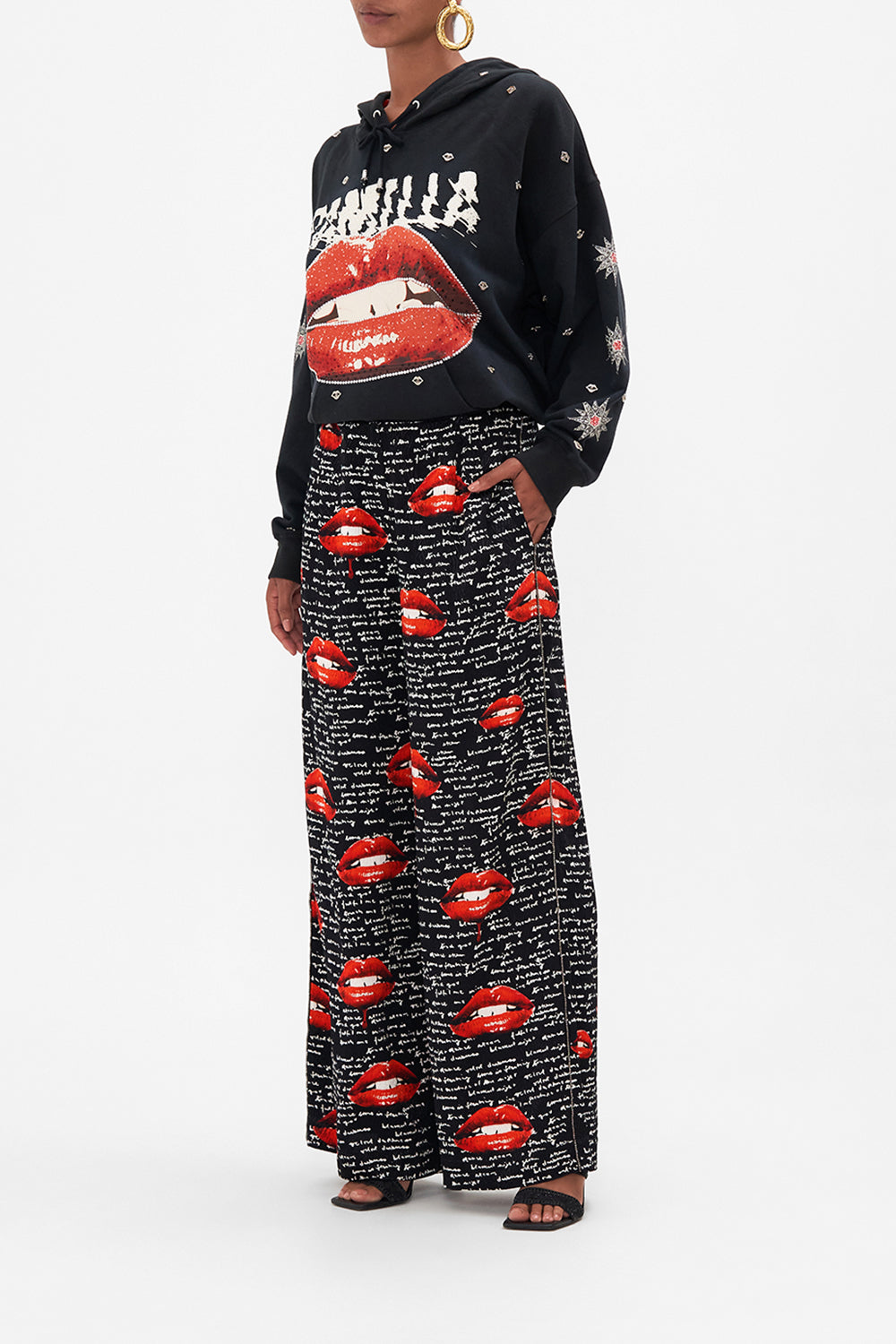 Side view of model wearing CAMILLA palazzo pants in black Chaos Magic print