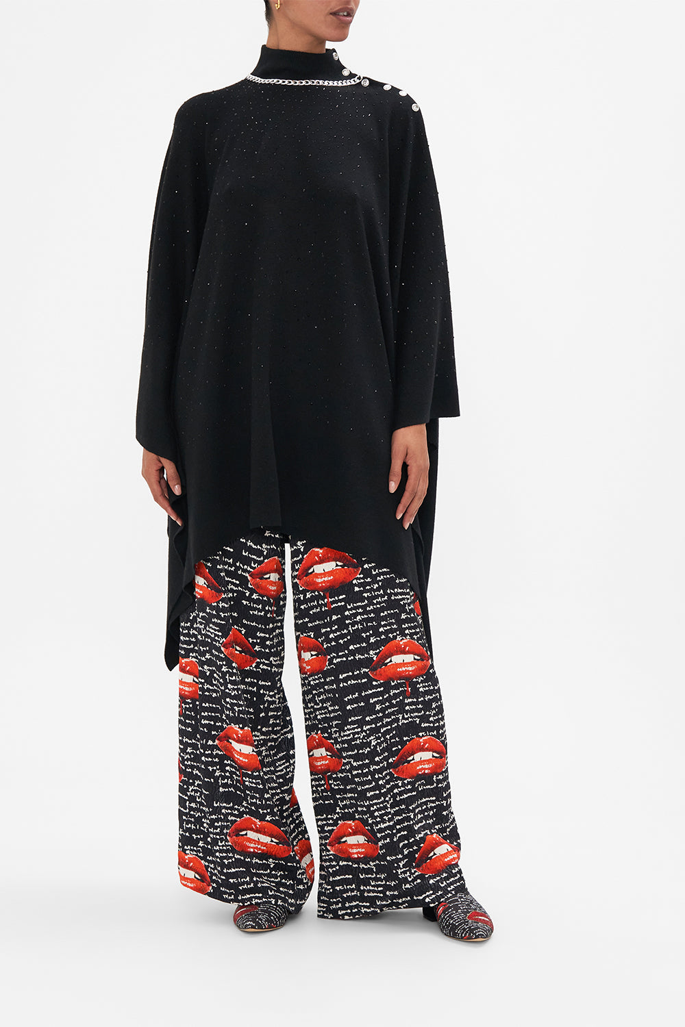 Front view of model wearing CAMILLA black knit poncho in Chaos Magic