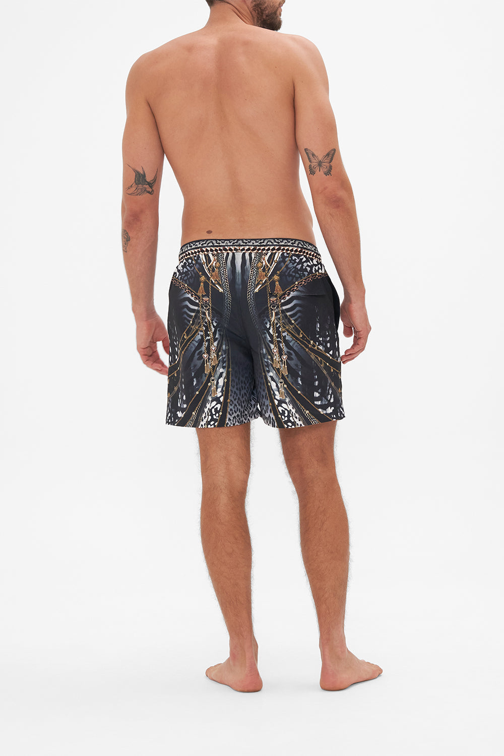 Back view of model wearing Hotel Franks by CAMILLA mens black boardshorts in Untamed Royalty print