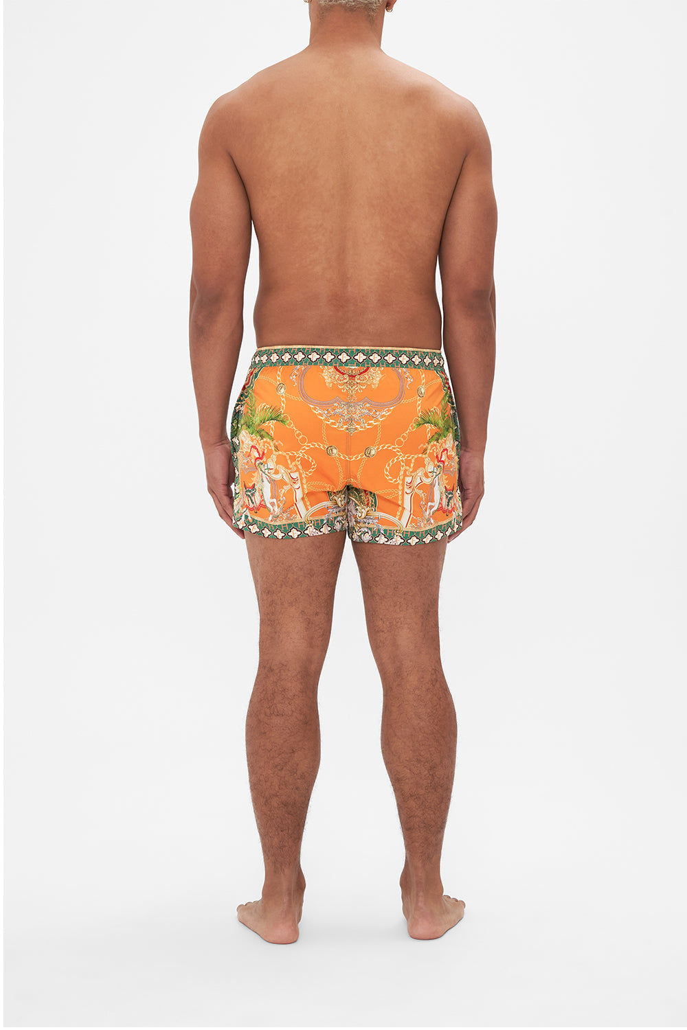 Back view of model wearing Hotel Franks by CAMILLA silk mens short boardshorts in orange Dancing With The Bulls print