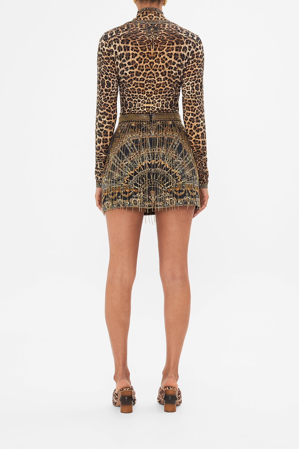 Back view of model wearing CAMILLA Crystal fringe mini skirt in Masked Moonlight print
