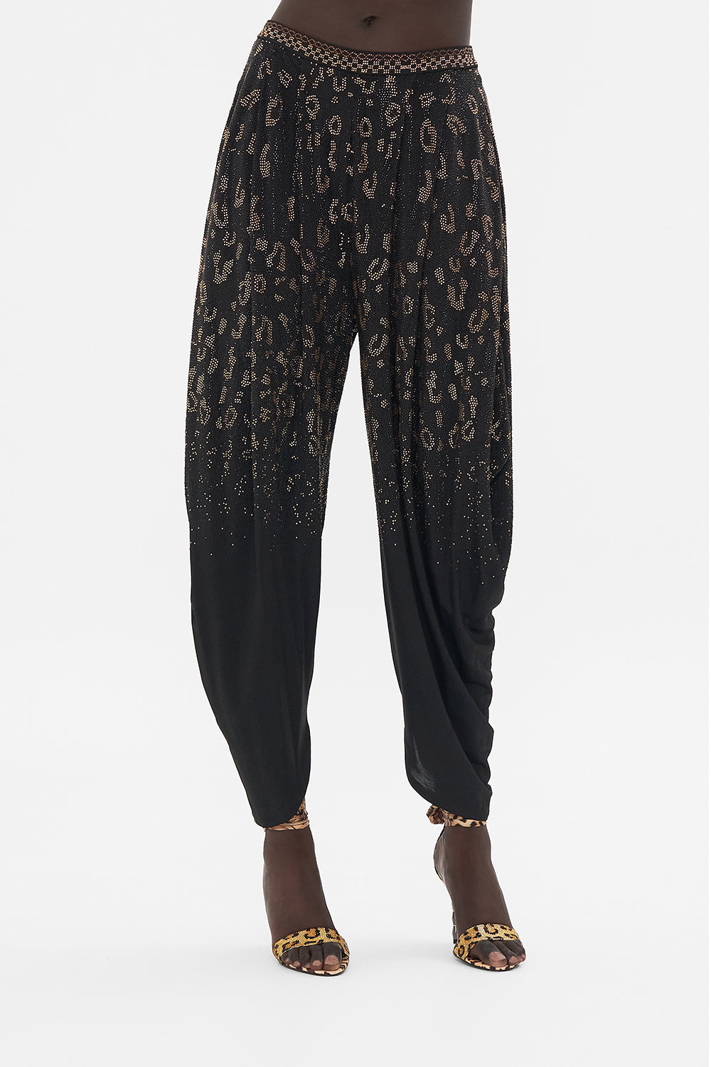 Detail view of model wearing CAMILLA black jersey pants in Mosaic Muse print