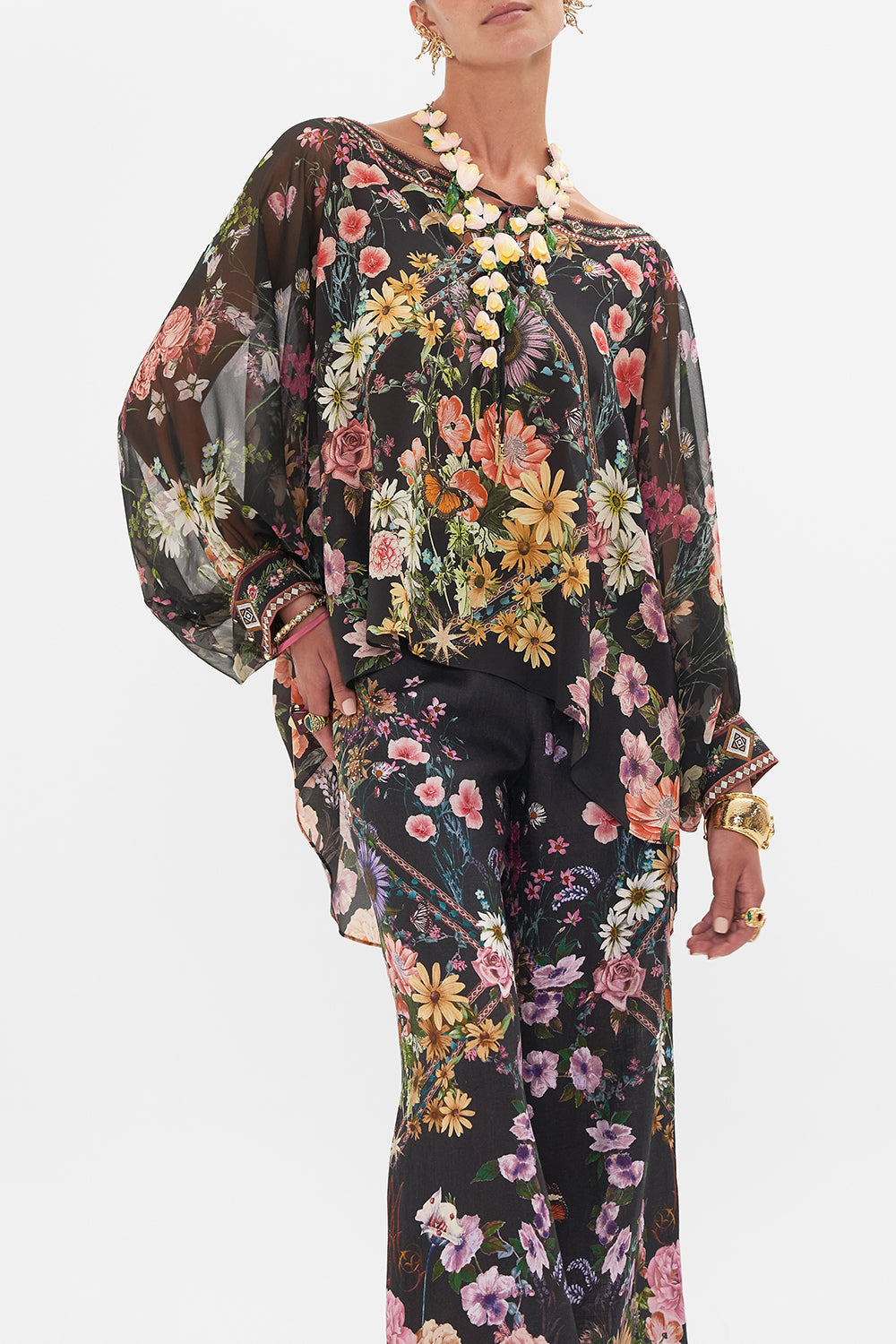 Crop view of model wearing CAMILLA silk blouse in Letters From A Vineyard print