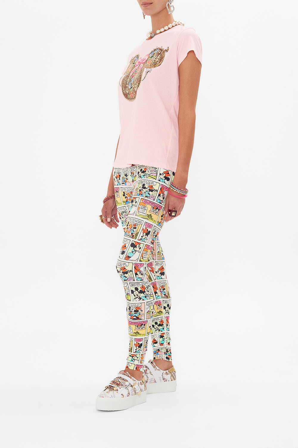 Side view of model wearing Disney x CAMILLA pink t shirt in Minnie Mouse Magic print