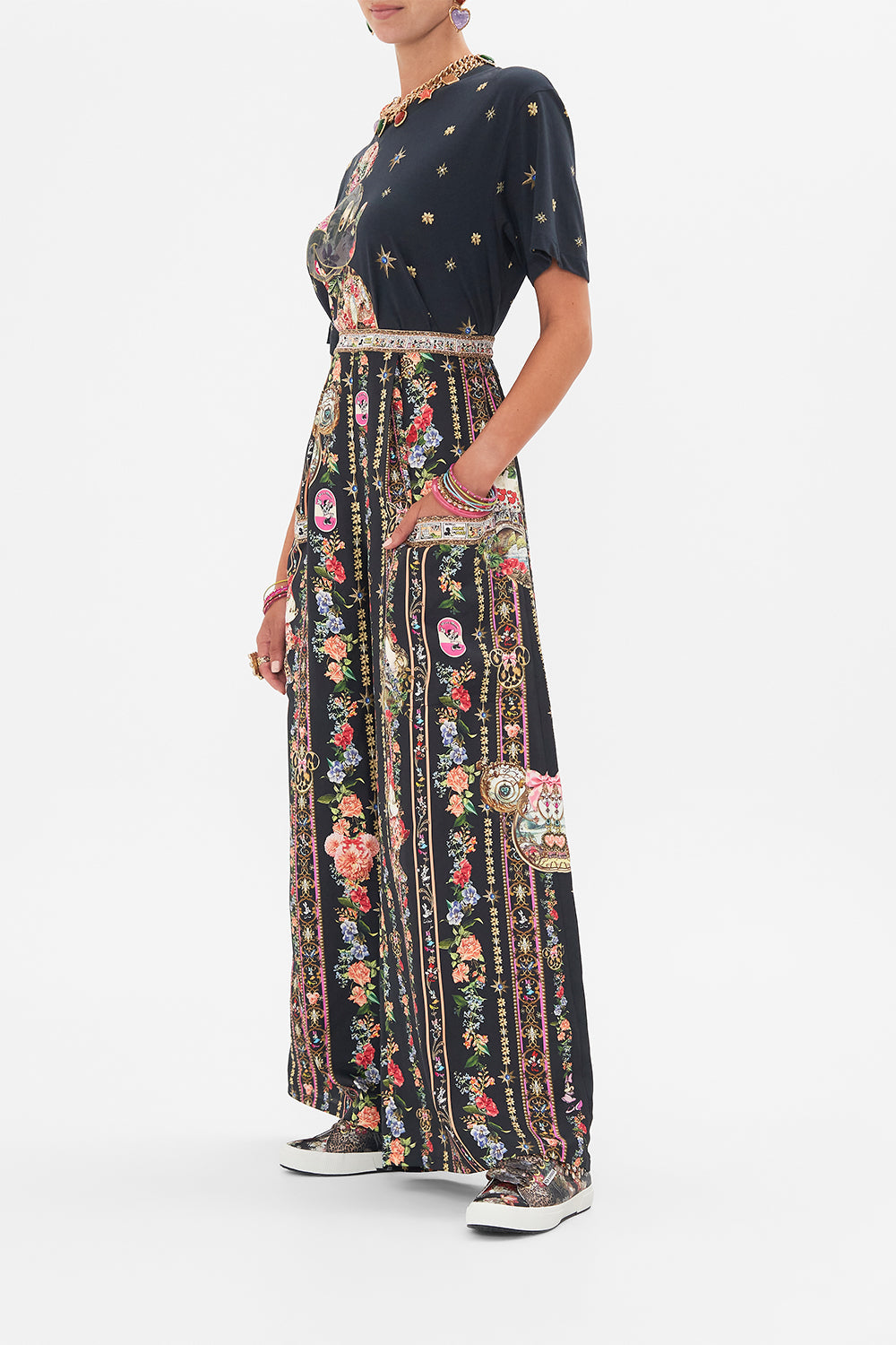 Side view of model wearing Disney x CAMILLA silk pants in Midnight At Minnies print
