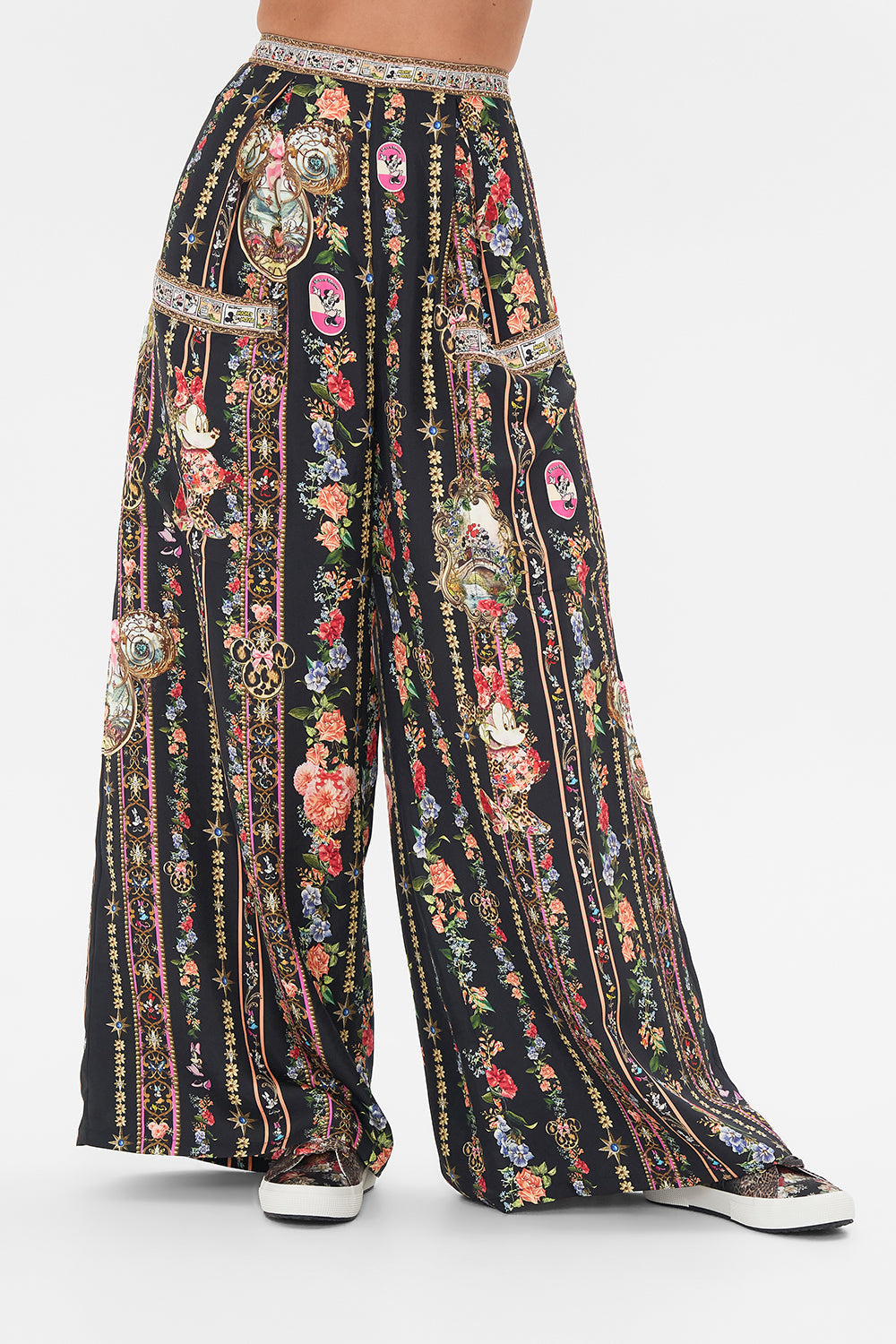 Crop view of model wearing Disney x CAMILLA silk pants in Midnight At Minnies print