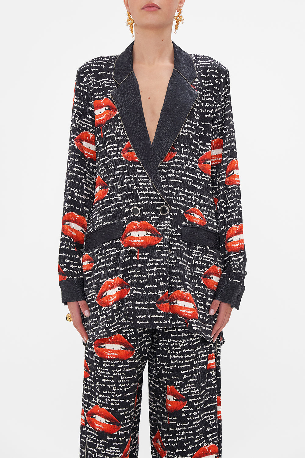 Crop view of model wearing CAMILLA black blazer in Chaos Magic print 