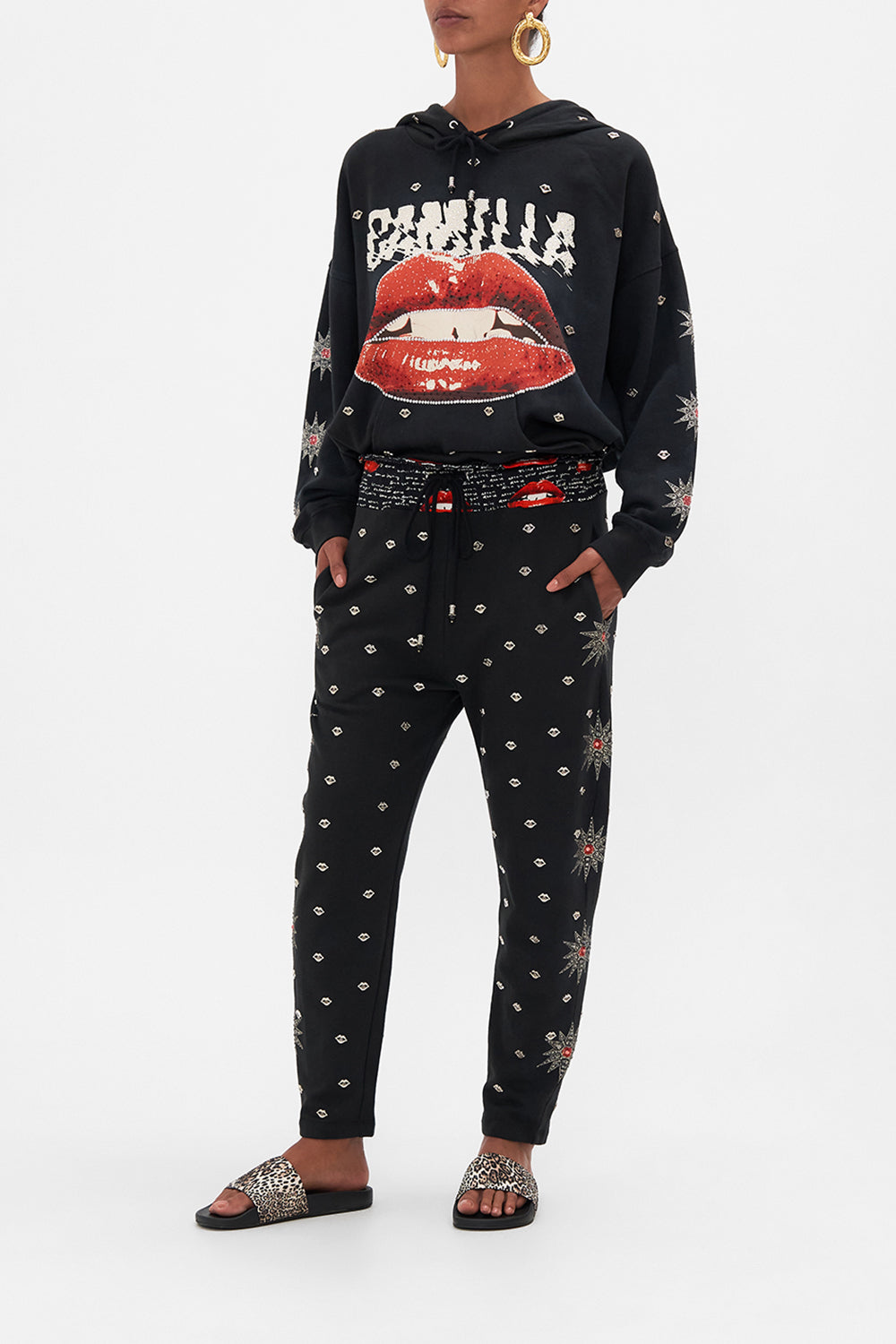 Side view of model wearing CAMILLA black trackpants in Chaos Magic print