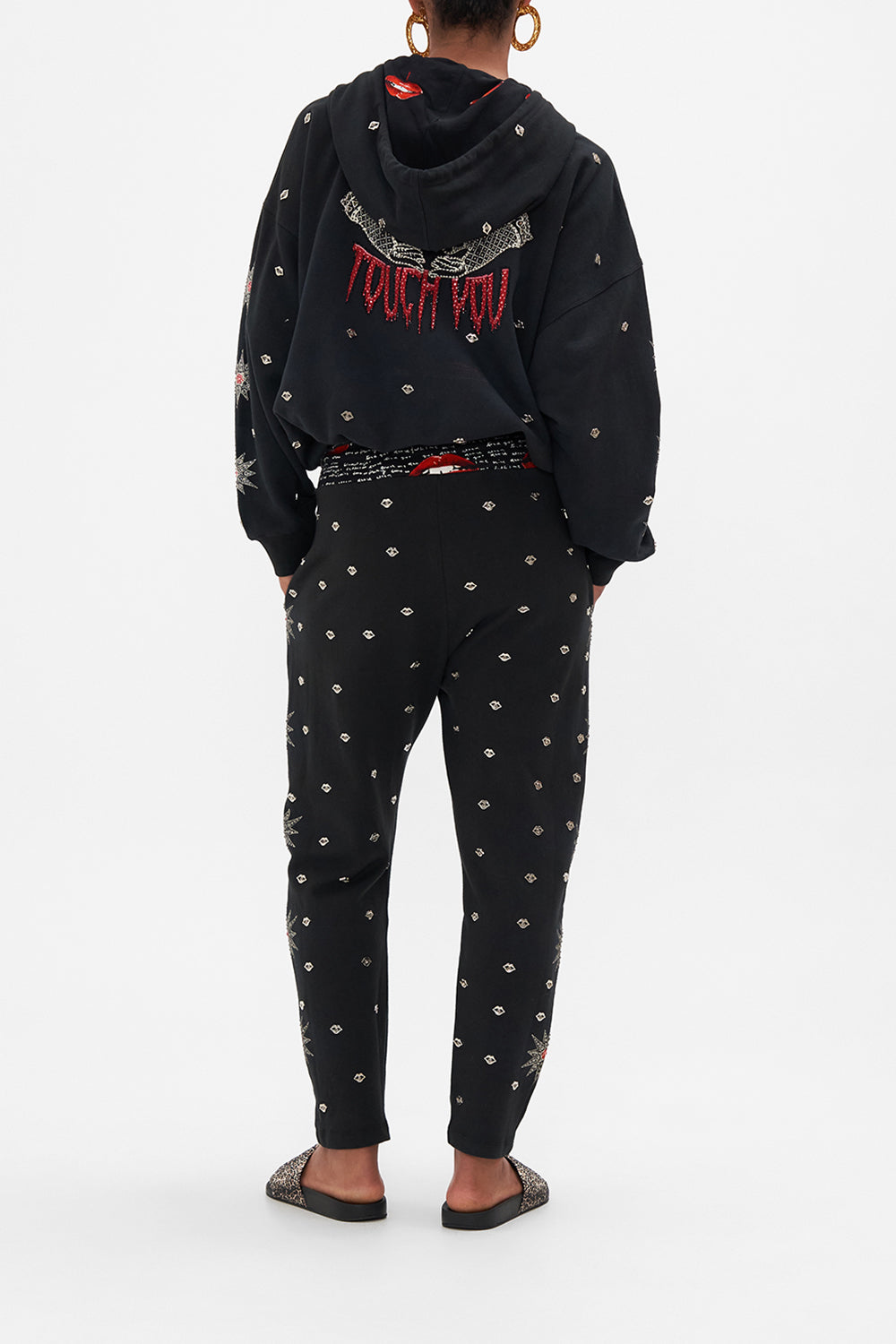 Back view of model wearing CAMILLA black trackpants in Chaos Magic print