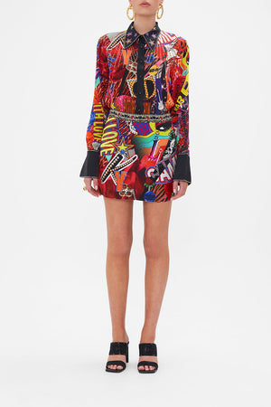 Front view of model wearing CAMILLA silk mini skirt in multicoloured Radical Rebirth print