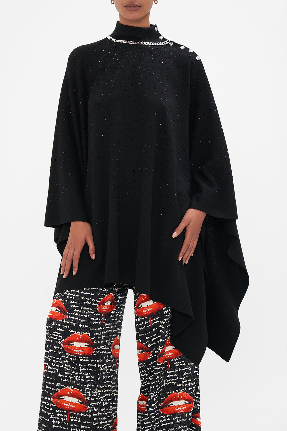 Crop view of model wearing CAMILLA black knit poncho in Chaos Magic 