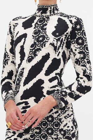 Detail view of model wearing CAMILLA black and white jersey midi dress in Feline Fantasy print