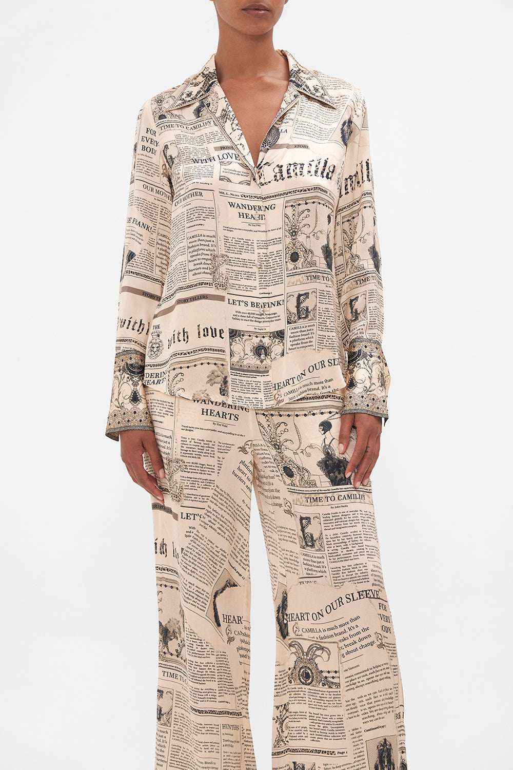 Crop view of model wearing CAMILLA pink silk pyjama shirt in Fame Fever print 