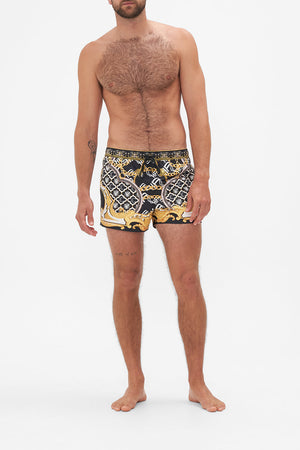 Front view of model wearing Hotel Franks by CAMILLA mens black swim shorts in Tether Me Not print