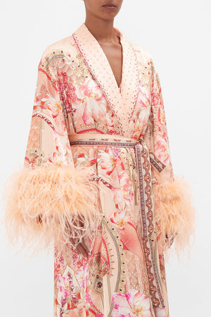 Crop view of model wearing CAMILLA silk robe with feathers in Adore Me pink floral print
