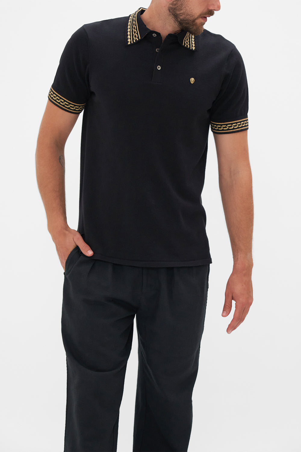 Crop view of model wearing Hotel Franks by CAMILLA mens black polo shirt in Tether Me Not print