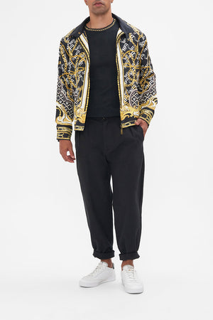 Front view of model wearing Hotel Franks by CAMILLA mens silk zip through jacket in black and gold Tether Me Not print