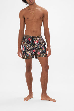 Front view of model wearing HOTEL FRANKS BY CAMILLA mens board short in A Night At The Opera floral print