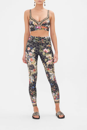 Front view of model wearing CAMILLA floral print activewear leggings in A Gift from the Baron print