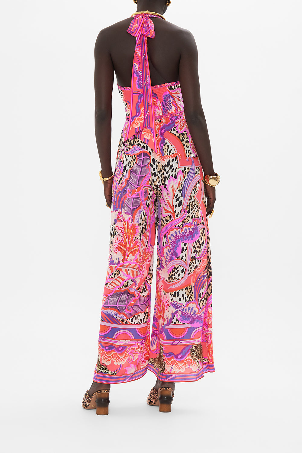 Back view of model wearing CAMILLA silk halterneck jumpsuit in Viola Vintage print