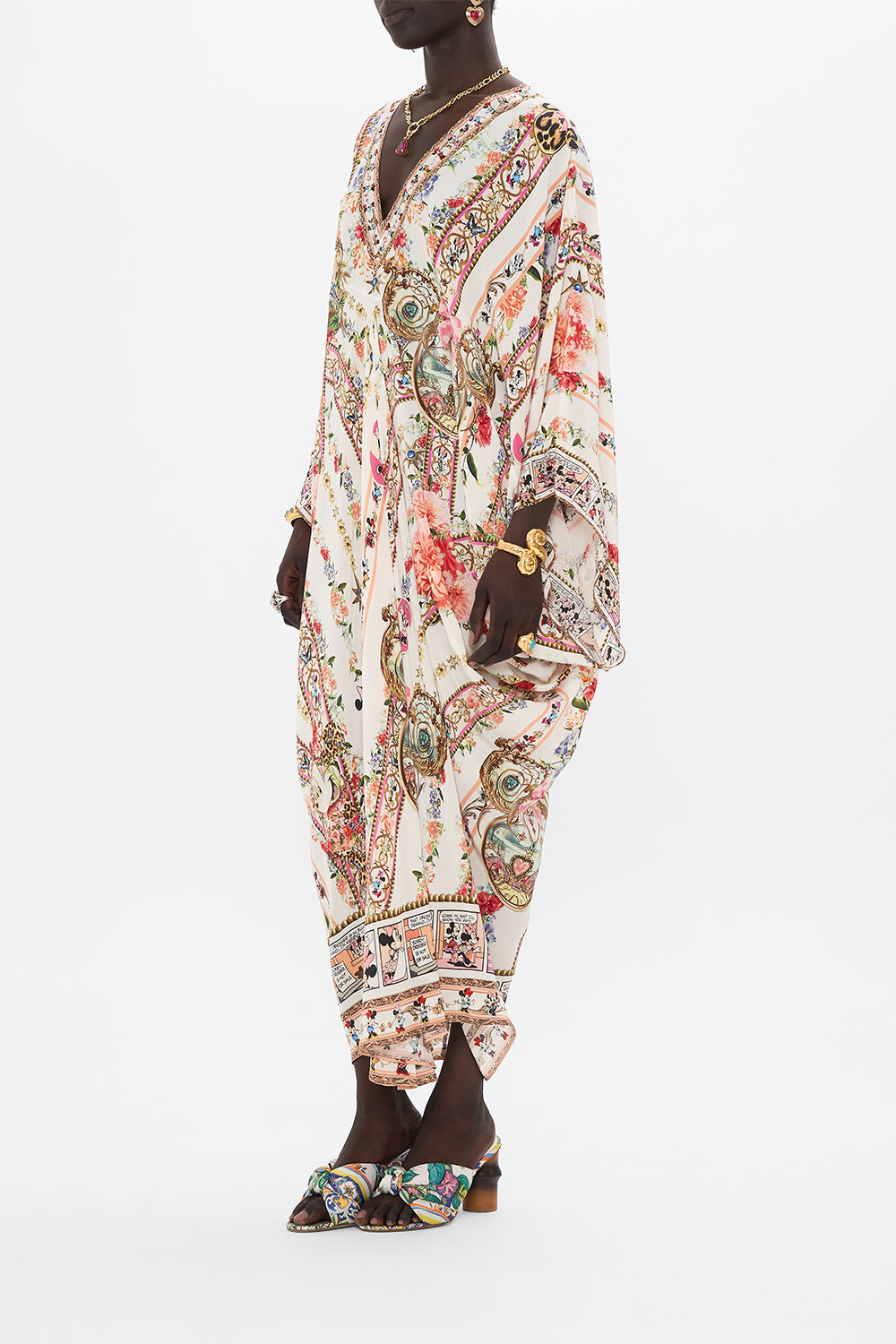 Side view of model wearing Disney x CAMILLA silk kaftan in Minnie Magic Forever print 