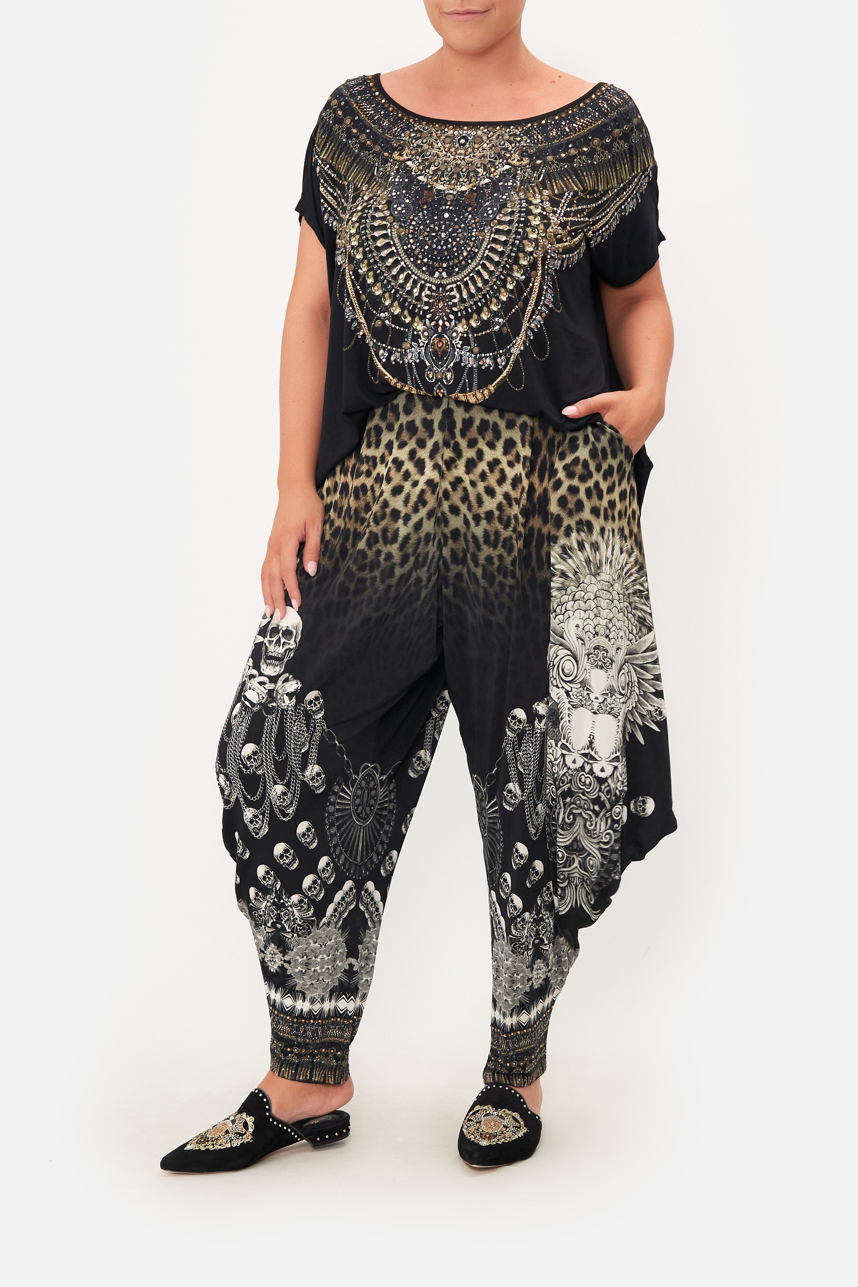Front view of curvy model wearing CAMILLA plus size drape pant in Order of Disorder print