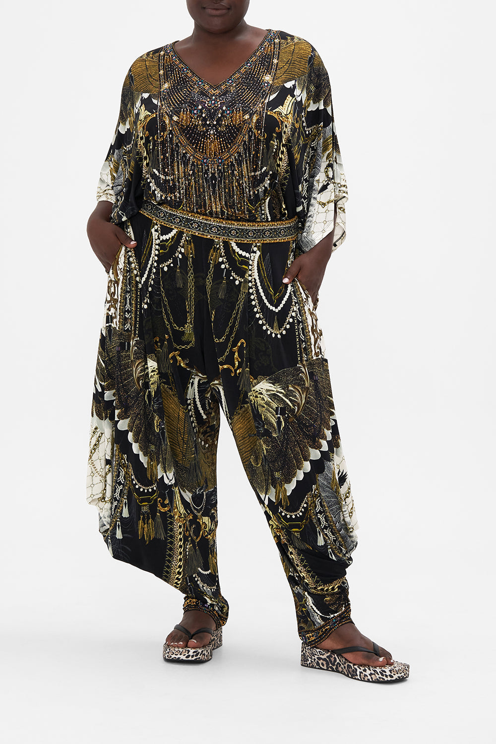 Front view of curvy model wearing CAMILLA plus size jersey pants on Ravin Raven print