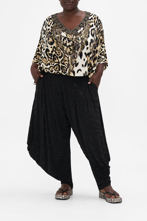 Front view of curvy model wearing CAMILLA plus size jersey drape pants in Tame My Tiger print